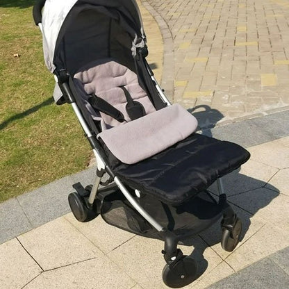 Poussette noire et grise équipée d'une chancelière bébé chaude et confortable, idéale pour les sorties en extérieur.