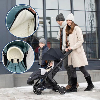 Famille en promenade hivernale, bébé confortablement installé dans une chancelière pour poussette chaude.