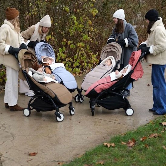 Promenade de plusieurs bébés installés confortablement dans des chancelières poussettes colorées