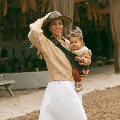 Maman au style bohème portant son bébé avec une écharpe de portage bébé confortable et élégante