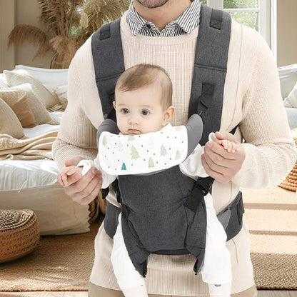 Papa tenant son bébé face avant dans un porte-bébé ergonomique gris clair, alliant confort optimal et design moderne.