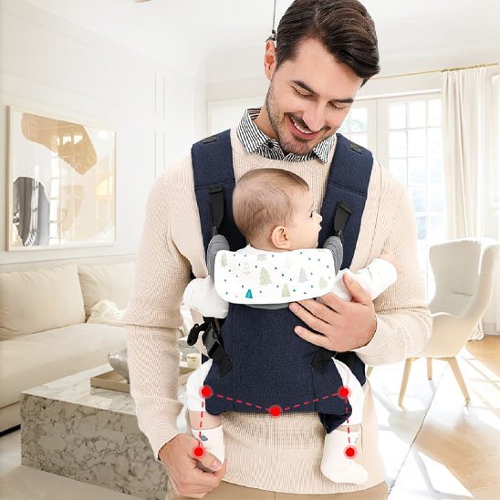 Papa regardant son bébé porté dans un porte-bébé ergonomique, conçu pour un confort optimal.