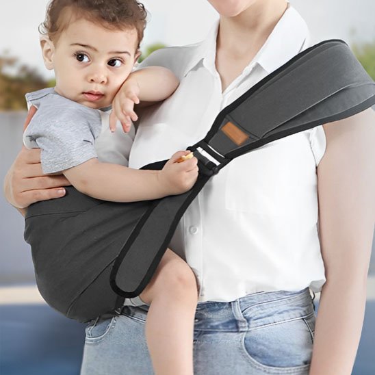 Maman portant son bébé dans un porte bébé ergonomique noir, parfait pour les sorties.