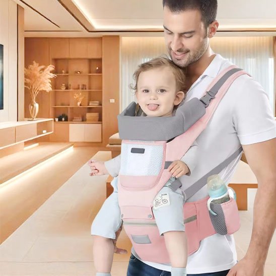 Papa souriant avec son bébé dans un porte-bébé ergonomique rose, design respirant et confortable pour le quotidien.