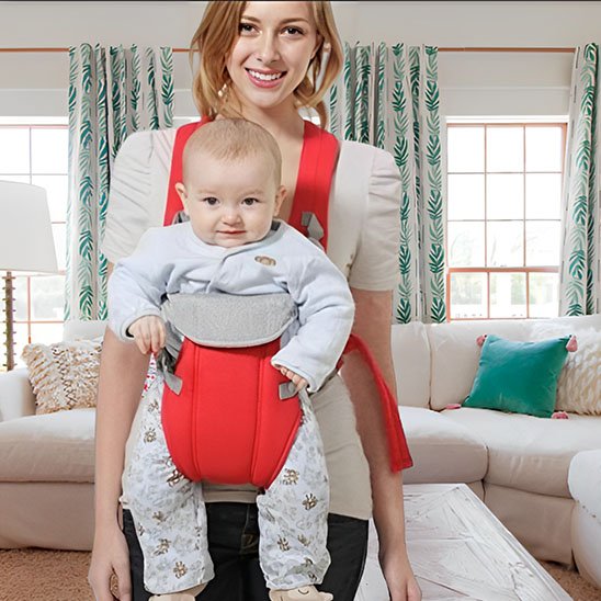 Maman portant son bébé dans un porte-bébé rouge ergonomique, idéal pour un portage confortable.