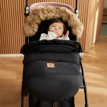 Bébé bien protégé du froid dans une chancelière noire pour poussette, ideale pour hiver.