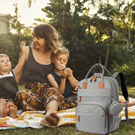 Maman assise avec ses enfants et un sac à langer gris