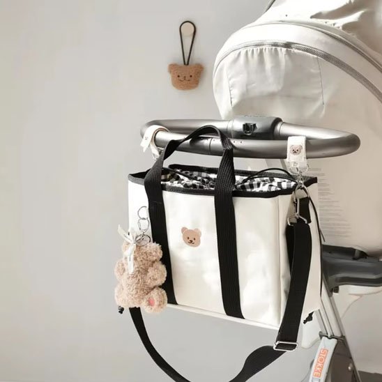 Sac à langer blanc fixé sur une poussette