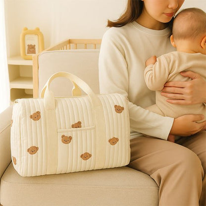 Sac à langer crème avec motifs posé sur une chaise