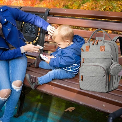 Maman assise sur un banc avec son bébé et un sac à langer gris