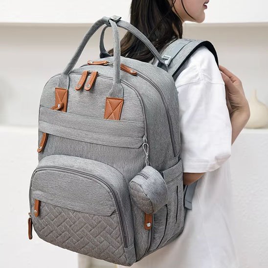 Sac à langer gris porté au dos comme un sac à dos pratique